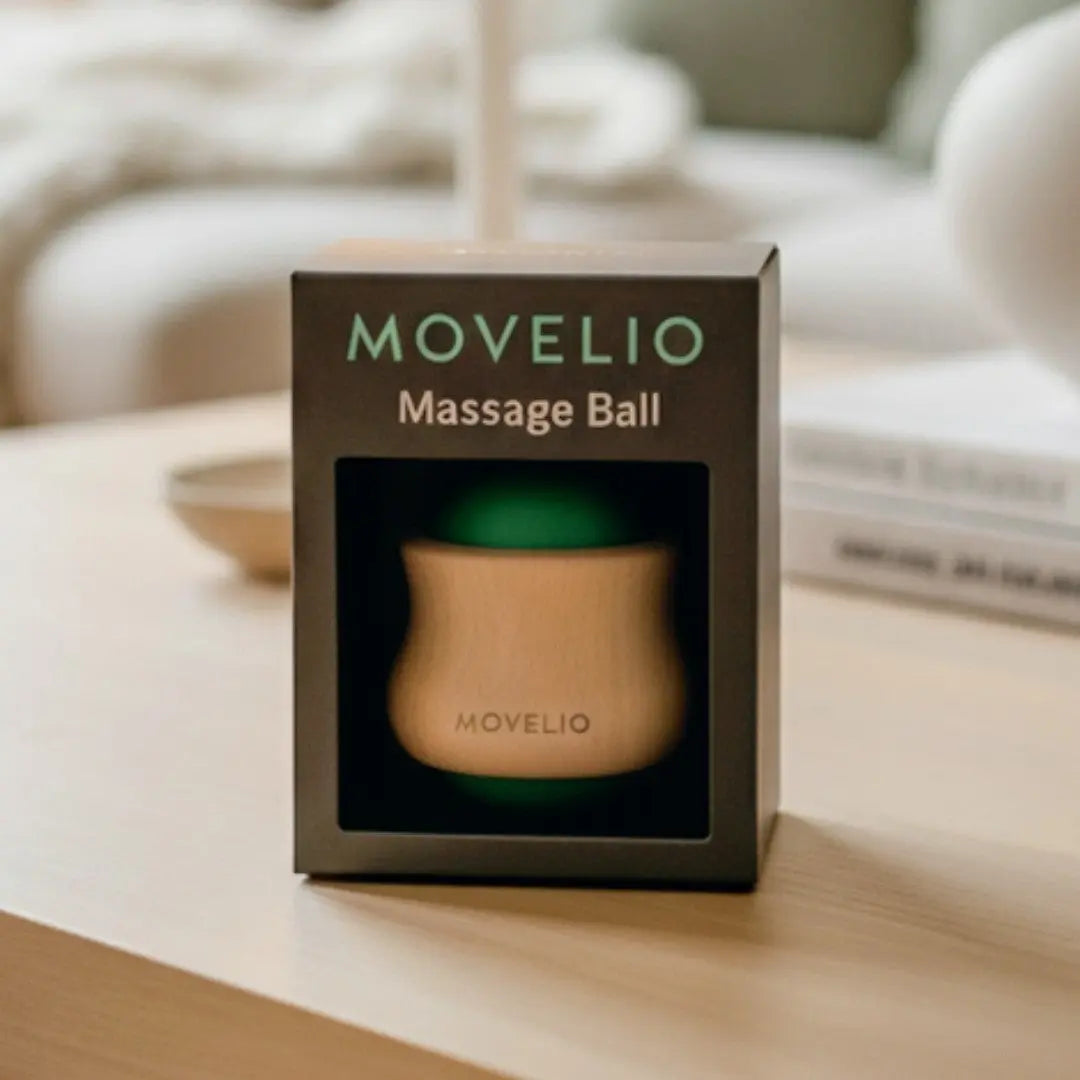 MOVELIO massage ball in packaging on a wooden surface