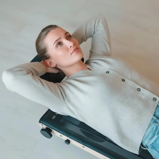Person using the MOVELIO Bed Roller to stretch and release tension in the upper back and shoulders.