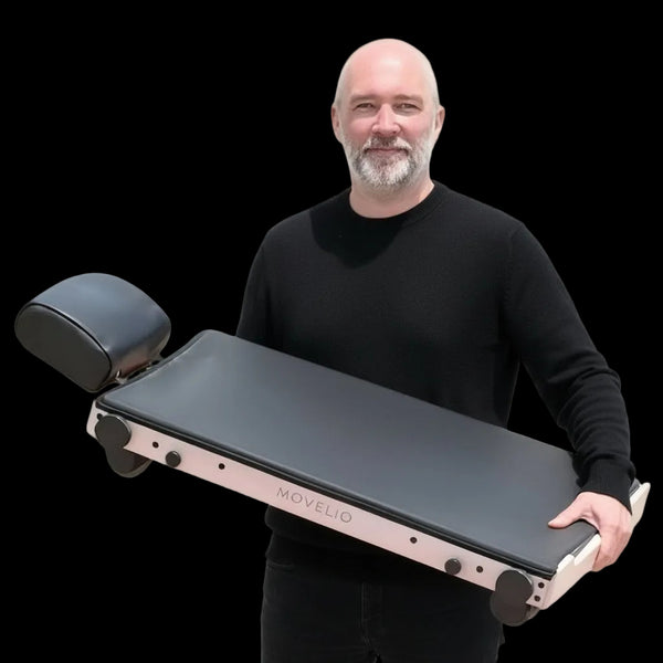 Photo of CEO and Founder of Movelio, Christopher Scheiene holding the Movelio Bed Roller. White background.