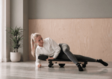 Woman using the MOVELIO Bed Roller on her hip and glute while lying on her side.
