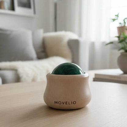 MOVELIO Massage Ball displayed on a table in a modern Scandinavian living room setting.
