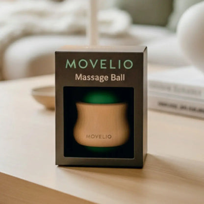 MOVELIO massage ball in packaging on a wooden surface