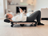 Woman using Movelio Bed Roller while viewing the Movelio Companion App