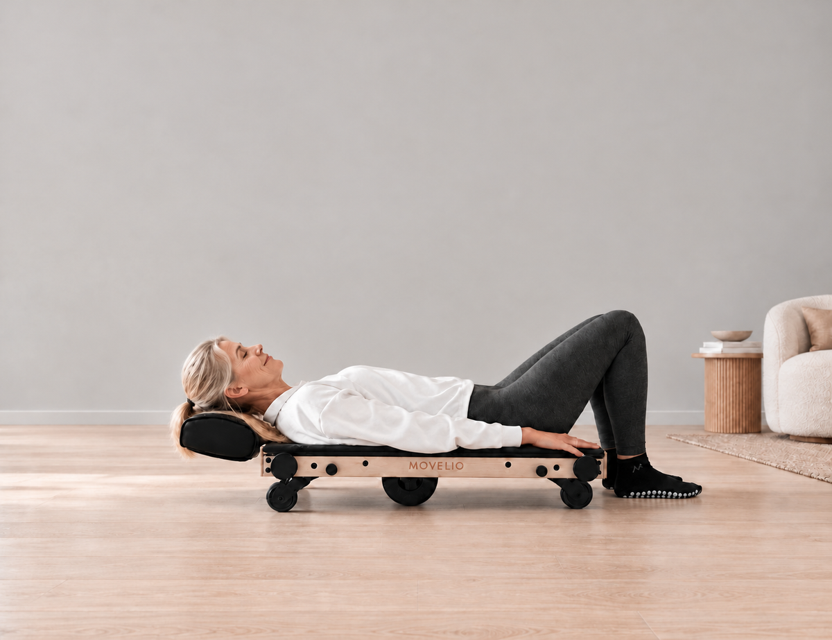 Person lying on Movelio Bed Roller with the roller under their back in a living room.