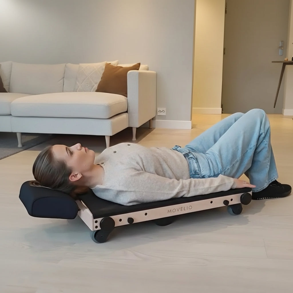 Person bei der selbst gesteuerten Rückenmassage mit dem Movelio Bed Roller
