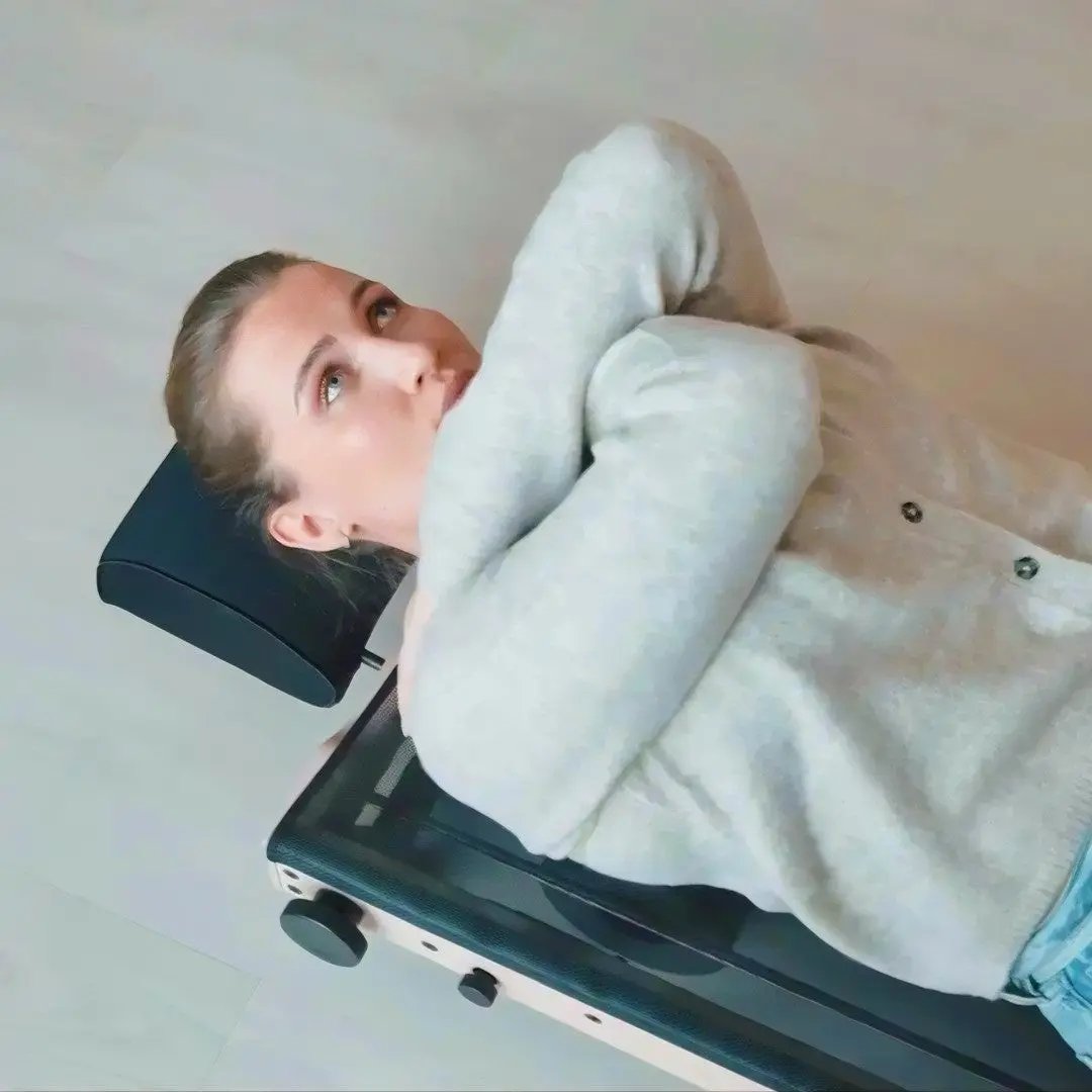 Person using the MOVELIO Bed Roller to stretch and release tension in the upper back and shoulders.