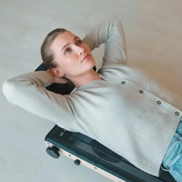 Person lying on Movelio Bed Roller with the roller positioned under the upper back.