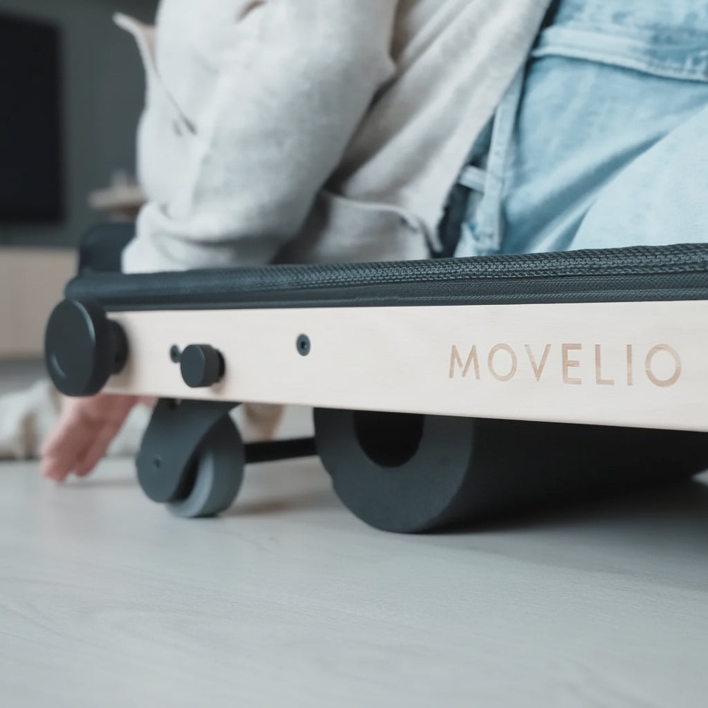 Close-up of a person using the MOVELIO Bed Roller for a gravity-based hip and lower back massage.