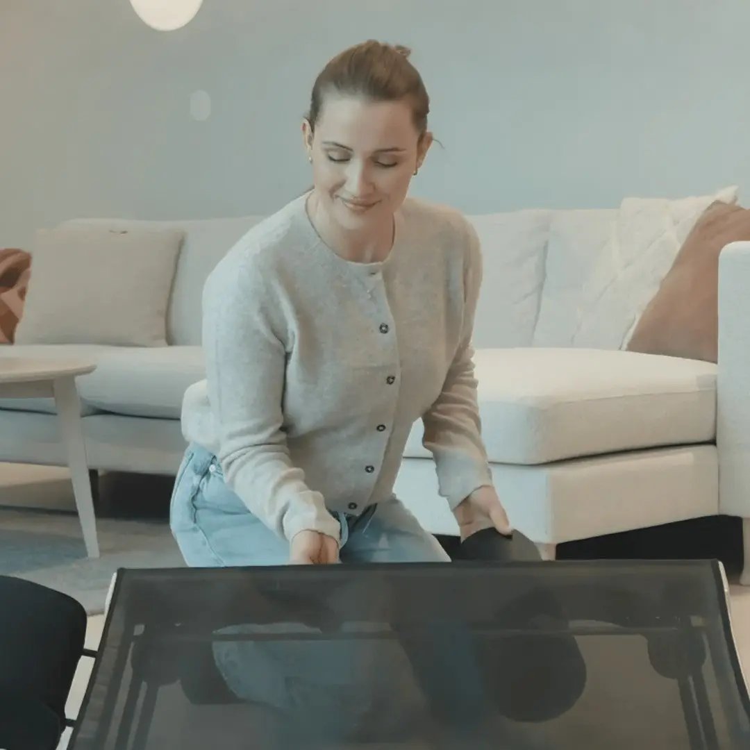 Person setting up the MOVELIO Bed Roller by placing the I-Roller attachment in a modern living room.